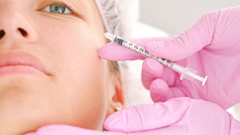 Close-up of a beautician administering facial injection treatment to a woman in a clinical setting.